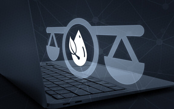 Environmental law concept with a glowing balance scale and leaf water drop symbol hovering above a laptop keyboard, representing ecological legal advice and sustainability regulations