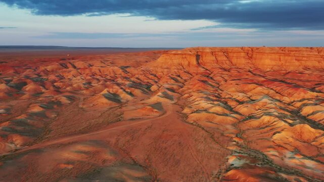 Aerial view of the colorful sedimentary rock formations of Tsagaan Suvarga under a dramatic sky in O'lziit, Dundgovi, Mongolia.