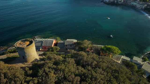 Marine de Meria Corsica drone flyover Genoese tower crescent beach golden hour late afternoon light, authentic village houses, rocky shore sweep, Cap Corse  D80 scenic winding coastal road