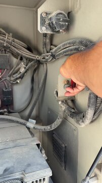 The electrical control and safety compartment of heavy machinery featuring a prominent main battery disconnect kill switch.