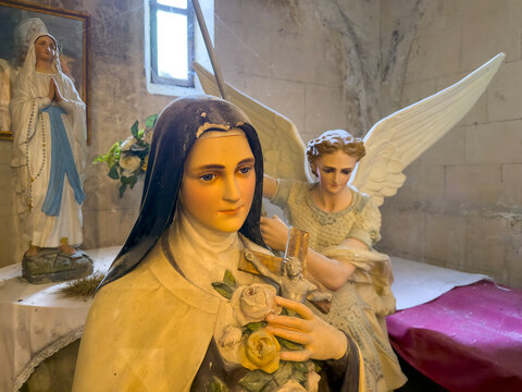 Painted plaster statues of Saint Therese, an angel and the Virgin Mary inside St. Peter collegiate church, Gers, La Romieu, France