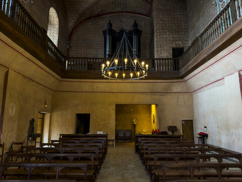 Nave view toward the pipe organ loft and wrought-iron chandelier at Saint Mary abbey, Gers, Boulor, France