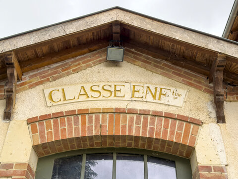Carved pediment reading 'Classe Enfantine' above the old schoolhouse window, Gers, Boulor, France