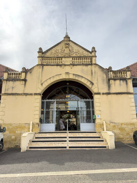 Ornate 1886 covered market hall entrance with pediment and coat of arms, Gers, Mirande, France