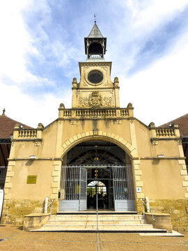 Covered market hall facade with bell tower and clock above the entrance, Gers, Mirande, France
