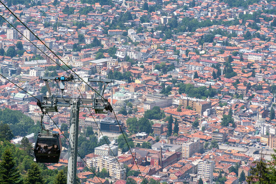 Sarajevo, Federation of Bosnia, Bosnia and Herzegovina - 16 June 2025: View of the Sarajevo Cable Car over the dense urban landscape with historic red-tiled rooftops and mosques.