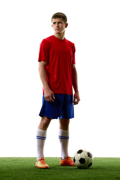 Full body young football player standing ready beside ball. Concept of team roster, player presentation, sports recruitment and match preparation.