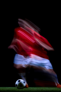 Abstract motion trail around young player controlling soccer ball. Concept of agility, fast footwork, athlete momentum and expressive sports backgrounds.