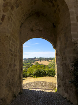 Stone archway framing a view of the countryside, Gers, Montesquiou, France