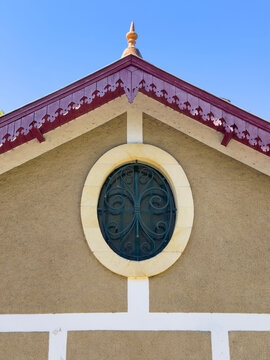 Ornate gable roof with an oval window and wrought iron grille, Gers, Montesquiou, France