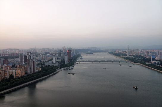 High-angle panoramic view of Taedong River and Pyongyang city skyline at twilight, North Korea
