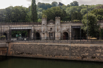 Crenellated gothic revival river frontage with turrets and pointed arches above the River Avon in Bath, Somerset. © Victor