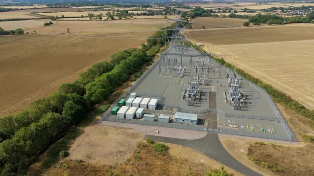 Aerial view of the National Grid Ryhall Substation featuring 400kV air-cooled transformers within a fenced compound surrounded by rural fields in Ryhall, England, United Kingdom.