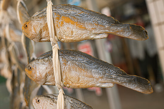 Dried yellow croakers tied with strings for sale market in south korea.