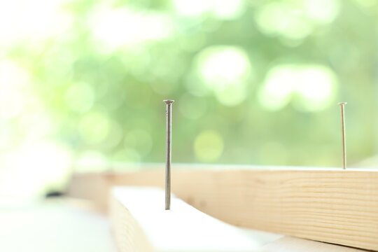 Wooden planks with metal nails indoors, closeup