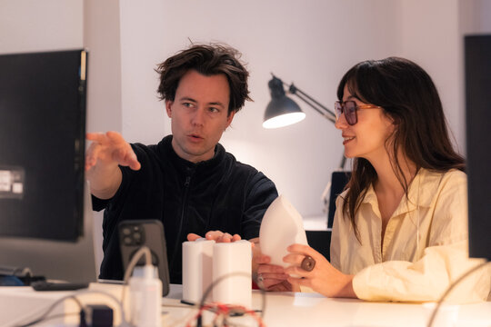 Creative designers are discussing project at computer