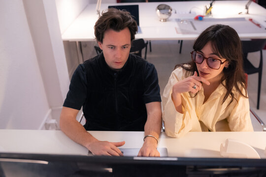 Designers work together on computer at office