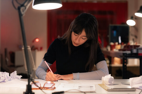 Focused woman sketching designs at office