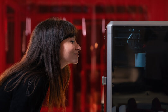 Happy curious woman watching 3d printing process