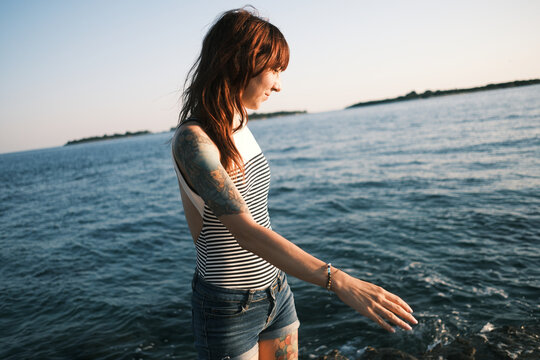 Woman touching the sea at golden hour