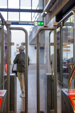 Back View of Passenger Passing through Metro Exit Doors