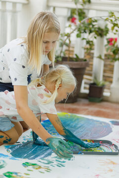 Little sisters enjoy finger painting