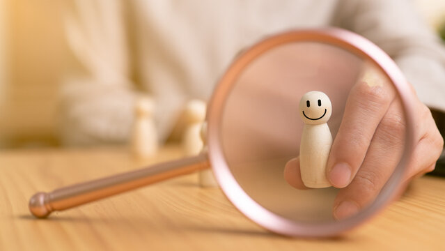 Hand selects a smiling wooden figure reflected in a round mirror, symbolizing the right person, right choice, confidence, positive mindset, recruitment, career decisions, and self-belief at work