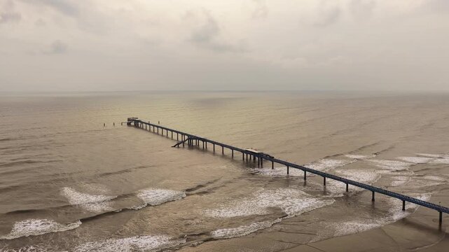 Aerial view of BD Navy Jetty extending into the Bay of Bengal with calm waves under an overcast sky in Cox's Bazar District, Chittagong Division, Bangladesh.