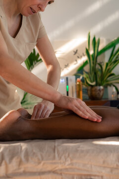 Focused therapist massaging client's legs