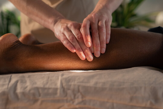 Therapist kneading woman's leg