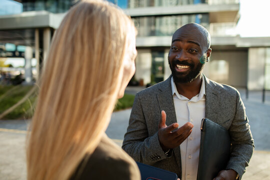 Business professionals networking outside modern office building