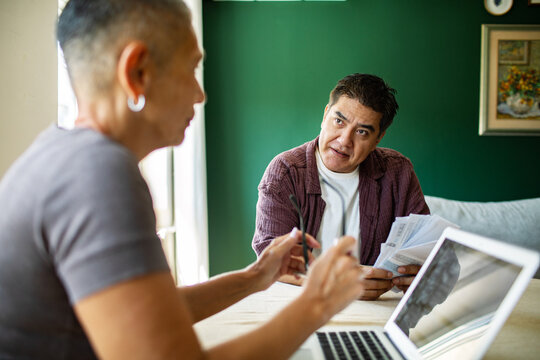 Two adults discussing household bills at home