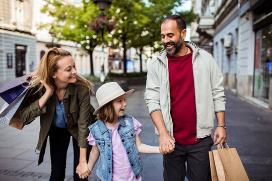 Happy family with child shopping on city street
