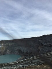 Volcanic crater lake with rocky cliffs and cloudy sky landscape view © Design_Vr