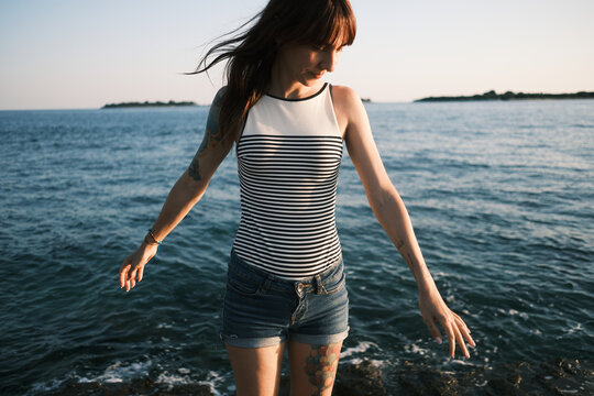 Woman balancing beside the sea