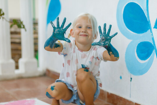 Happy child enjoys finger painting