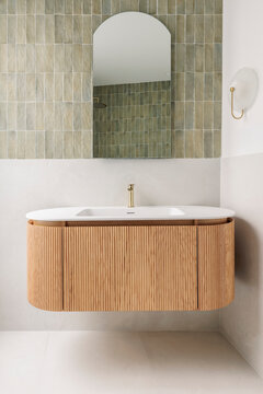 Floating wooden vanity with arched mirror