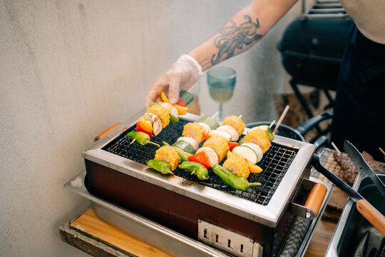 Cooking Colorful Skewers on a Grill in a Backyard Setting