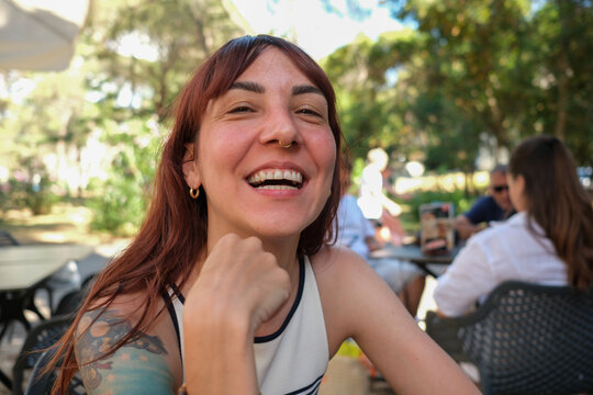 Laughing woman at outdoor caf&eacute;