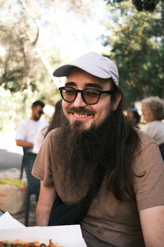 Smiling bearded man sitting outdoors
