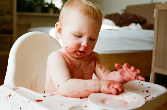 Toddler enjoys messy eating in a home setting