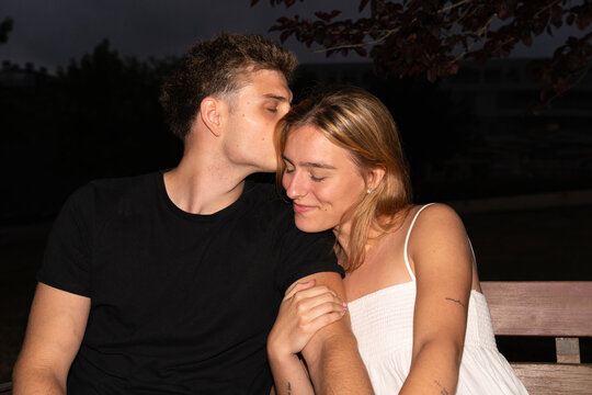 Couple Sitting on a Bench During Evening Hours