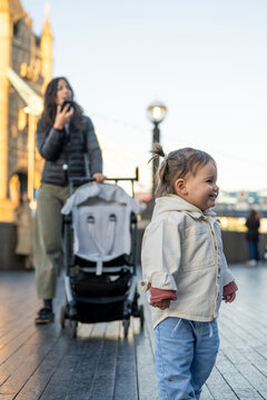 Mother talking on Smartphone While Walking With Baby