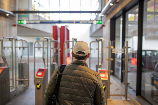 Back View of Commuter Walking through Metro Gates