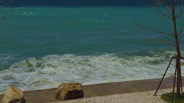 Turquoise Sea Waves Crashing Foam Against Coastal Embankment Promenade. Mediterranean Marine Coastline 