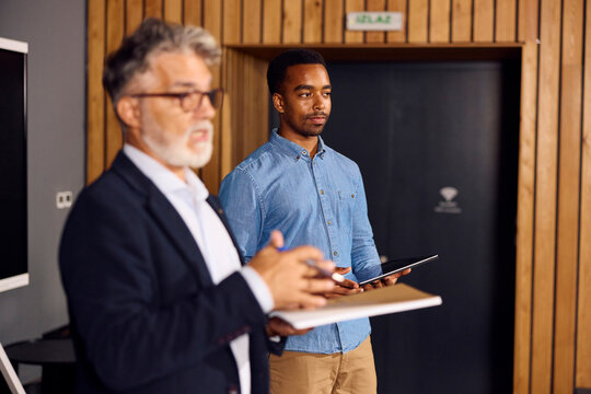 Business Meeting With Two Men Presenting Ideas