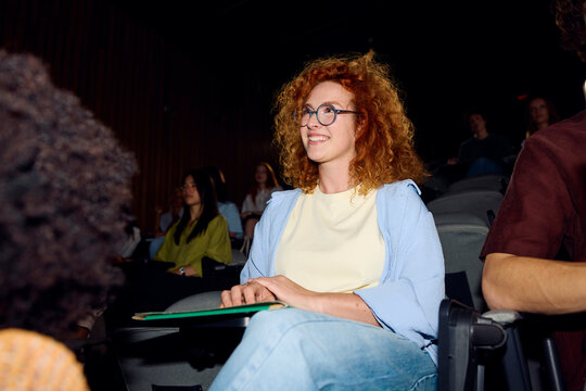 Beautiful young woman follows lecture at the university