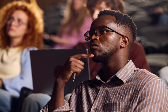 Man Listening During a Lecture in a Crowded Classroom