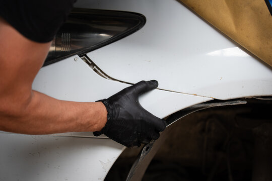 Mechanic Installing Car Bumper