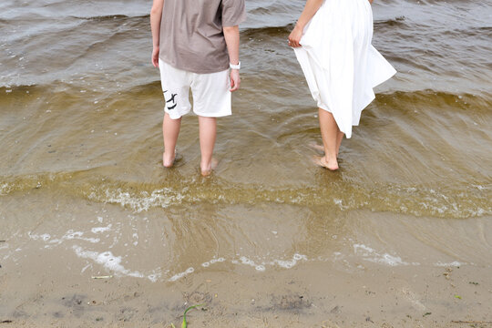 A mother and son are walking by the river.